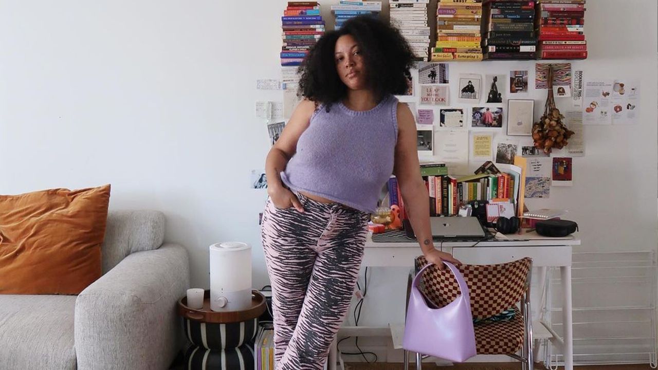 Influencer Posing in Purple Outfit in Front of Bookshelf