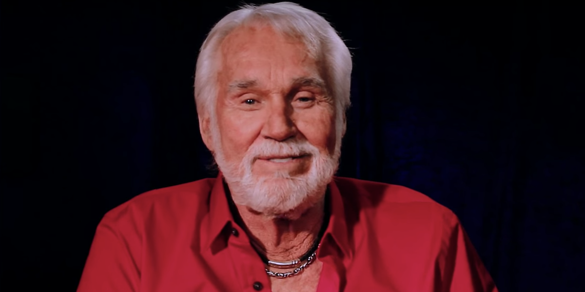 Kenny Rogers smiles and looks into the camera while giving a message to his fans in a 2015 video cal