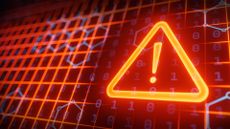 Cyber attack concept image showing orange glowing alert symbol imposed over digital systems mesh.