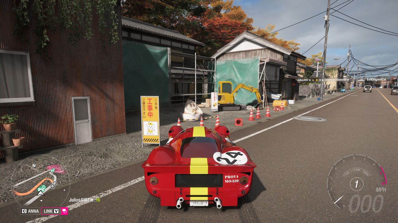 FH6 tank latte: A classic red Ferrari parked on a main road opposite a large latte mascot by a small building site.