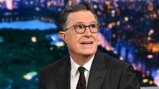 Stephen Colbert smiling and looking up and to his right.