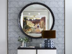 Entryway with wallpaper and circular mirror