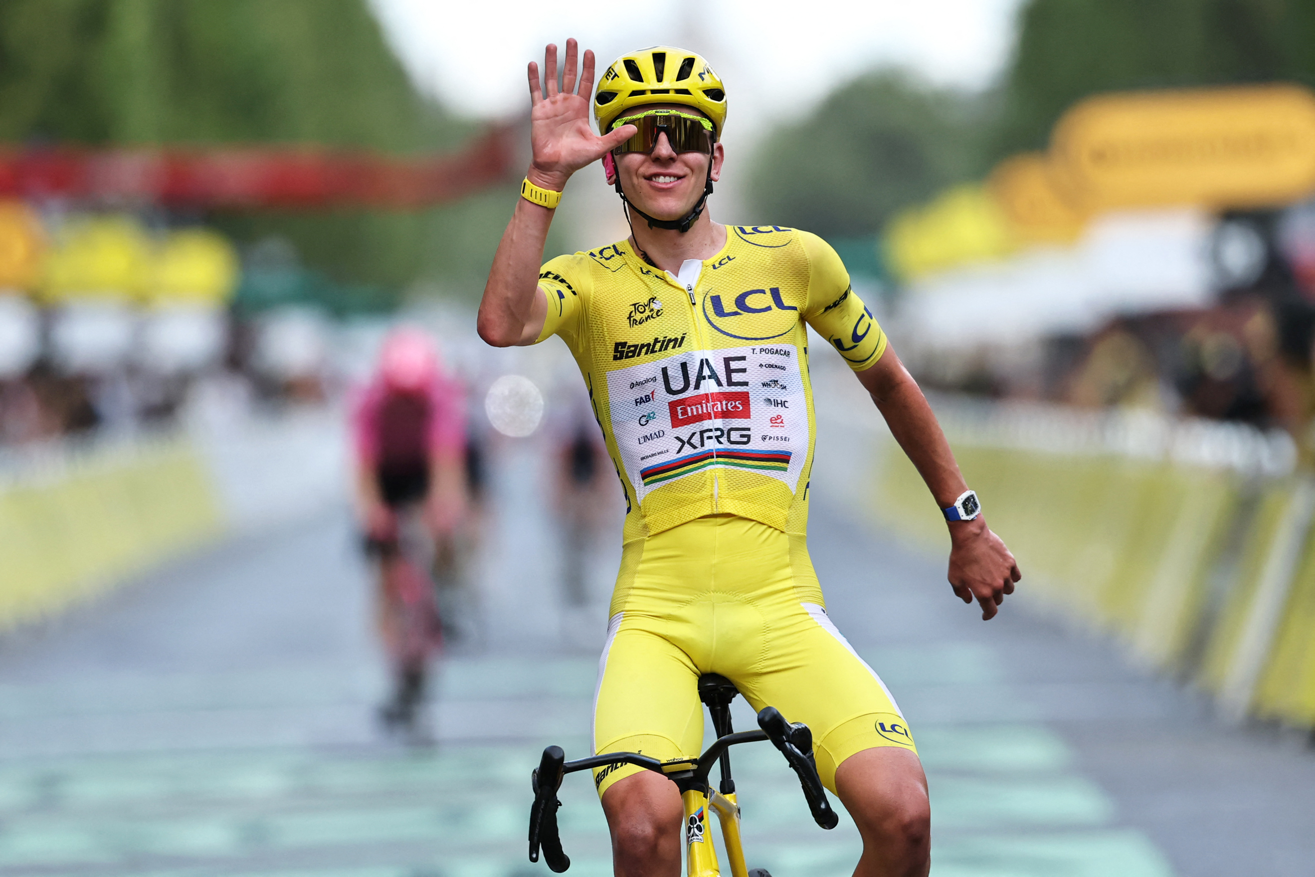 Tadej Pogačar celebrates his overall victory as he crosses the finish line of stage 21 of the Tour de France