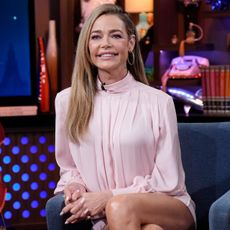 denise richards wearing a baby pink long sleeve dress