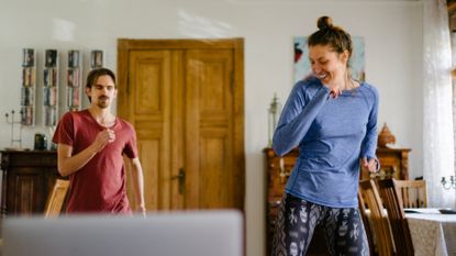 Man and woman doing a step-based workout at home