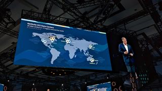 A worldmap of NetSuite data centers, with each represented by a pin. It is being shown on a huge screen on the keynote stage at SuiteWorld 2023.
