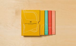 Mustard yellows, monochromes, turquoises and bold reds are displayed prominently across the cards and book jackets