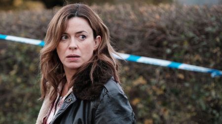 Eve Myles looks away from police crime scene tape