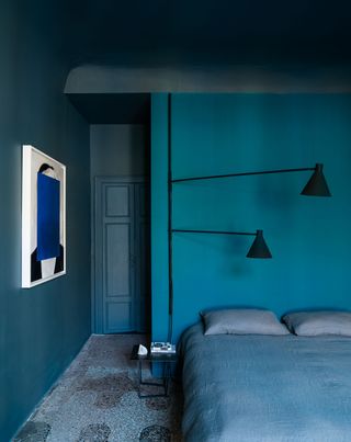 A bedroom with turquoise walls and blue bedding