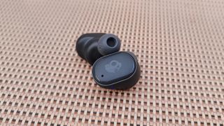 Both Skullcandy Grind Fuel wireless earbuds resting on a lawn chair