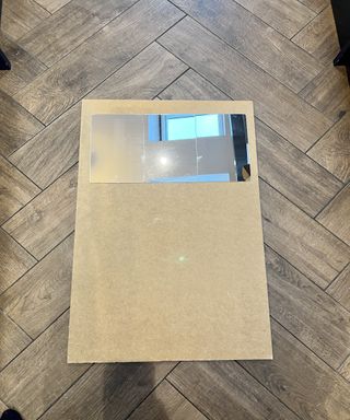 Wooden base of mirror on wooden tile floor with mirror tiles on