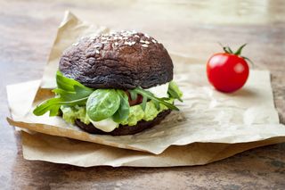 Vitamin D recipes: Grilled portobello bun mushroom burger. Vegan, gluten free, grain free, healthy veggies hamburger with guacamole, fresh vegetables and cashew cheese sauce. Copy space