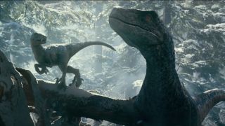 Blue and her baby together in the snowy woods in Jurassic World: Dominion.