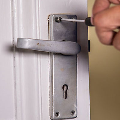removing an old internal door handle with a screwdriver
