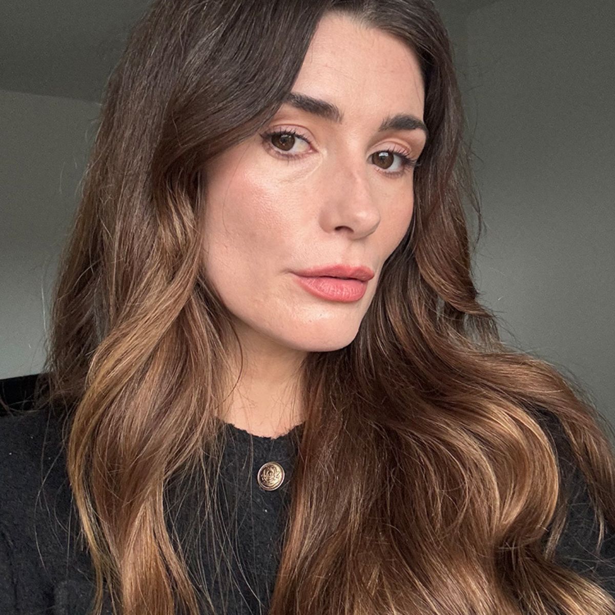 A selfie of Eleanor wearing Chanel makeup and a black cardigan