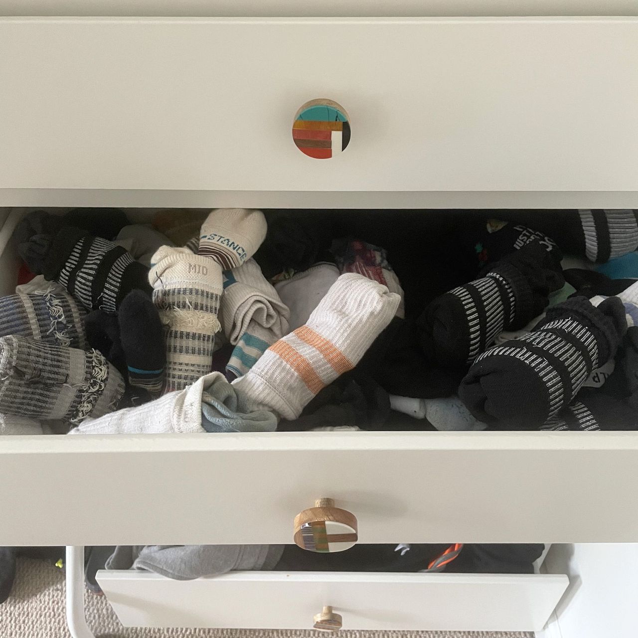 Messy socks in a white chest of drawers