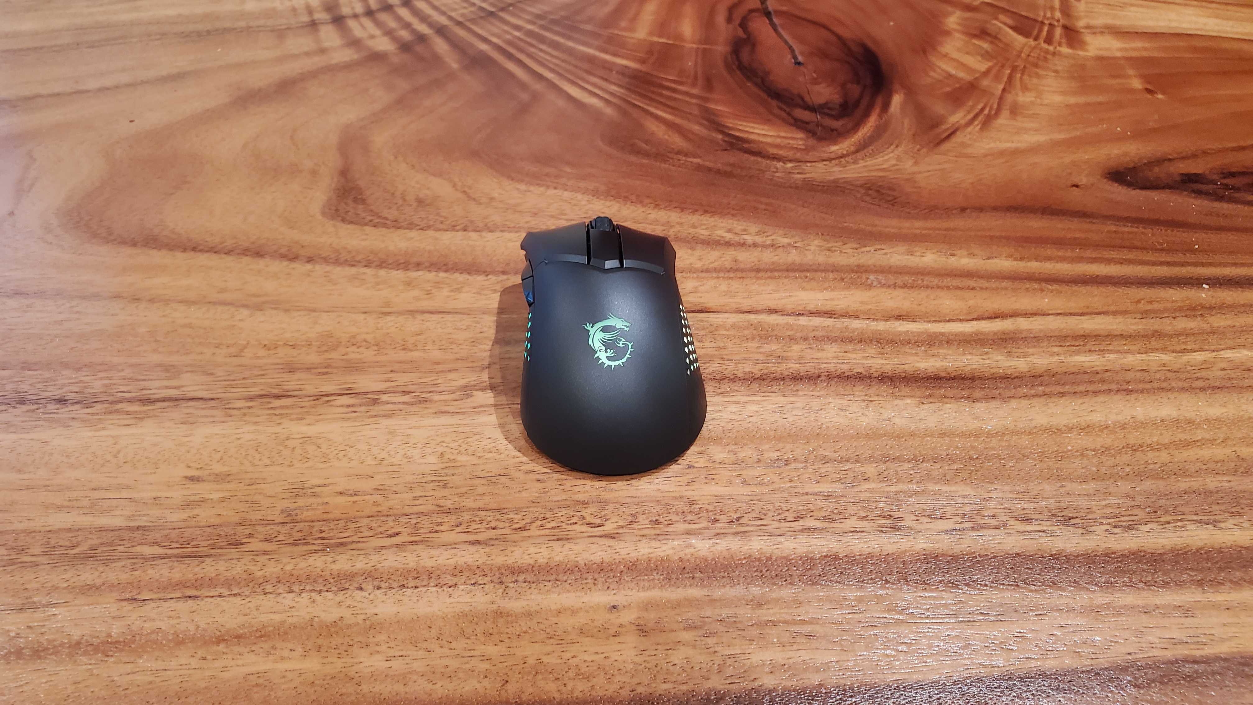 mouse de jogo preto em uma mesa de madeira