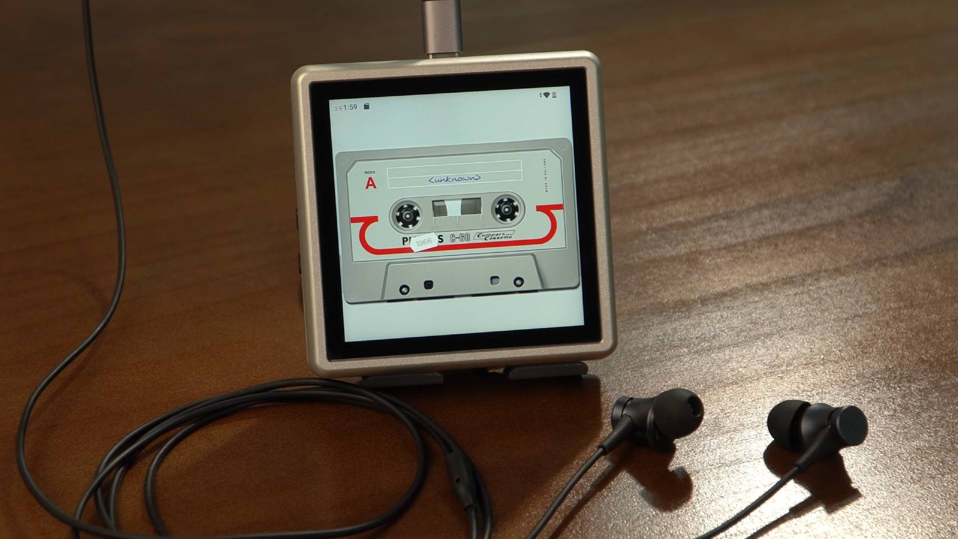 Anbernic RG Rotate with buttons folded in and tape animation on screen with USB-C earbuds connected.