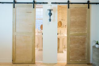 studio's bathrooms feature traditional hex tiling, pedestal sinks and sliding loft doors