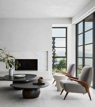 A living room with light grey chairs and a black coffee table