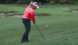 A golfer hits a shot from the rough in the Puma DRYLBL Women's Golf Rain Pants