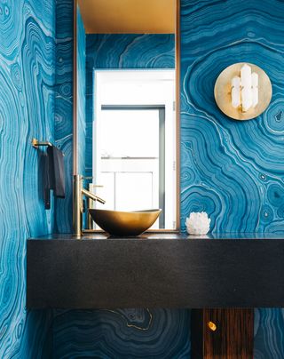 a small bathroom with a bold blue wall mural