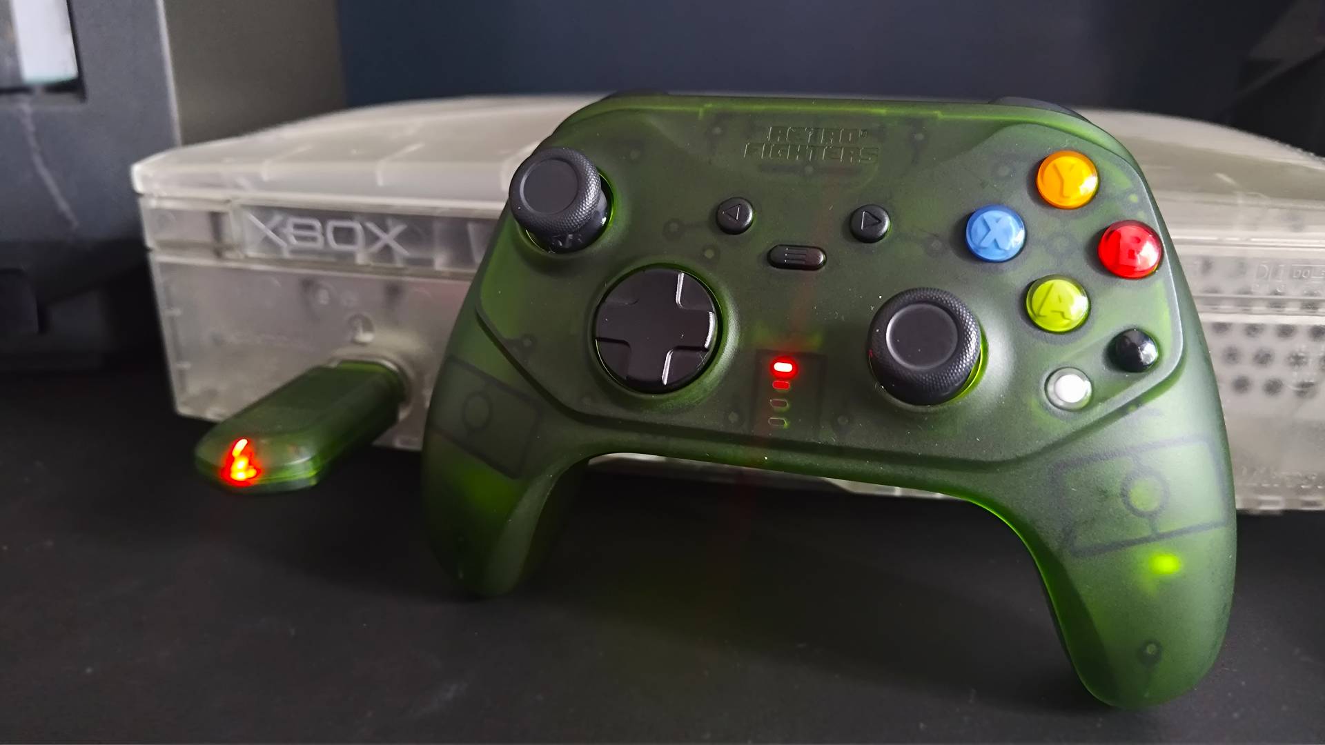 Retro Fighters Hunter leaning against OG Xbox console with receiver in port 1.