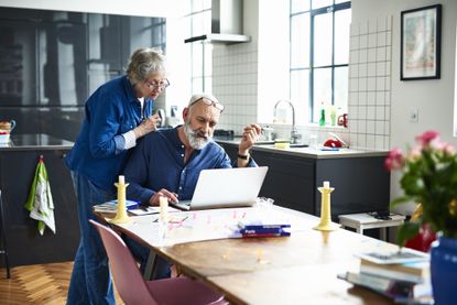 A couple looks at a computer doing planning for retirement.