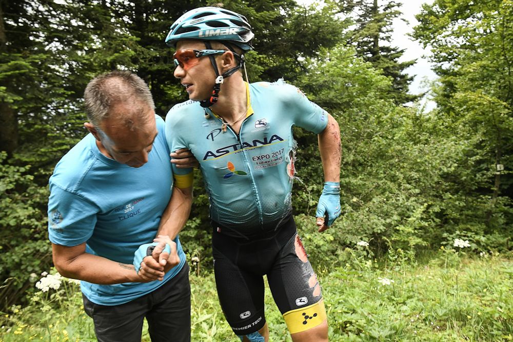 Kazakhstan's Alexey Lutsenko receives assistance after falling during the 181.5 km ninth stage