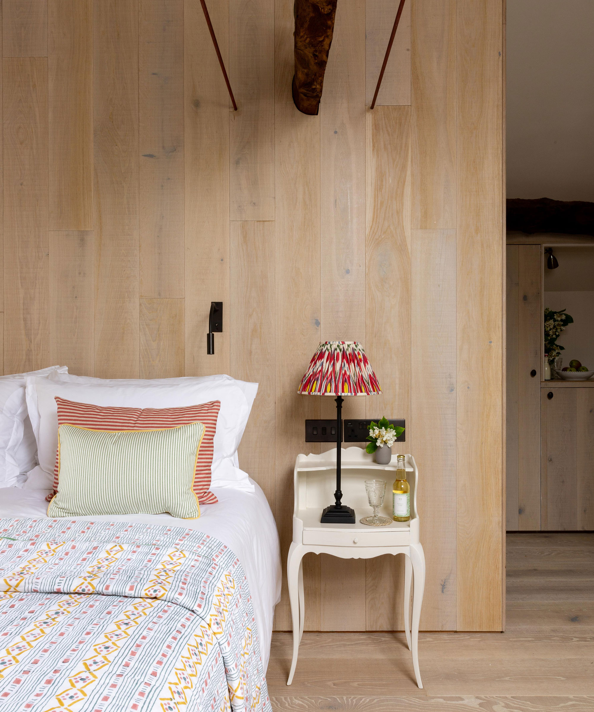 bedroom with pale timber wall cladding and matching engineered timber floors