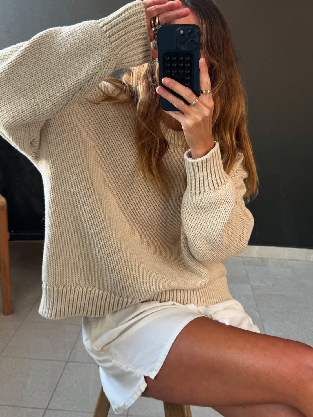 Angie wears a cream knit jumper