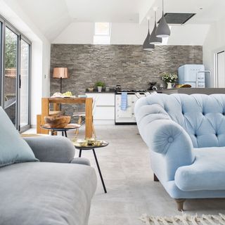 kitchen with grey brick designed wall bifold door blue sofa and lamp
