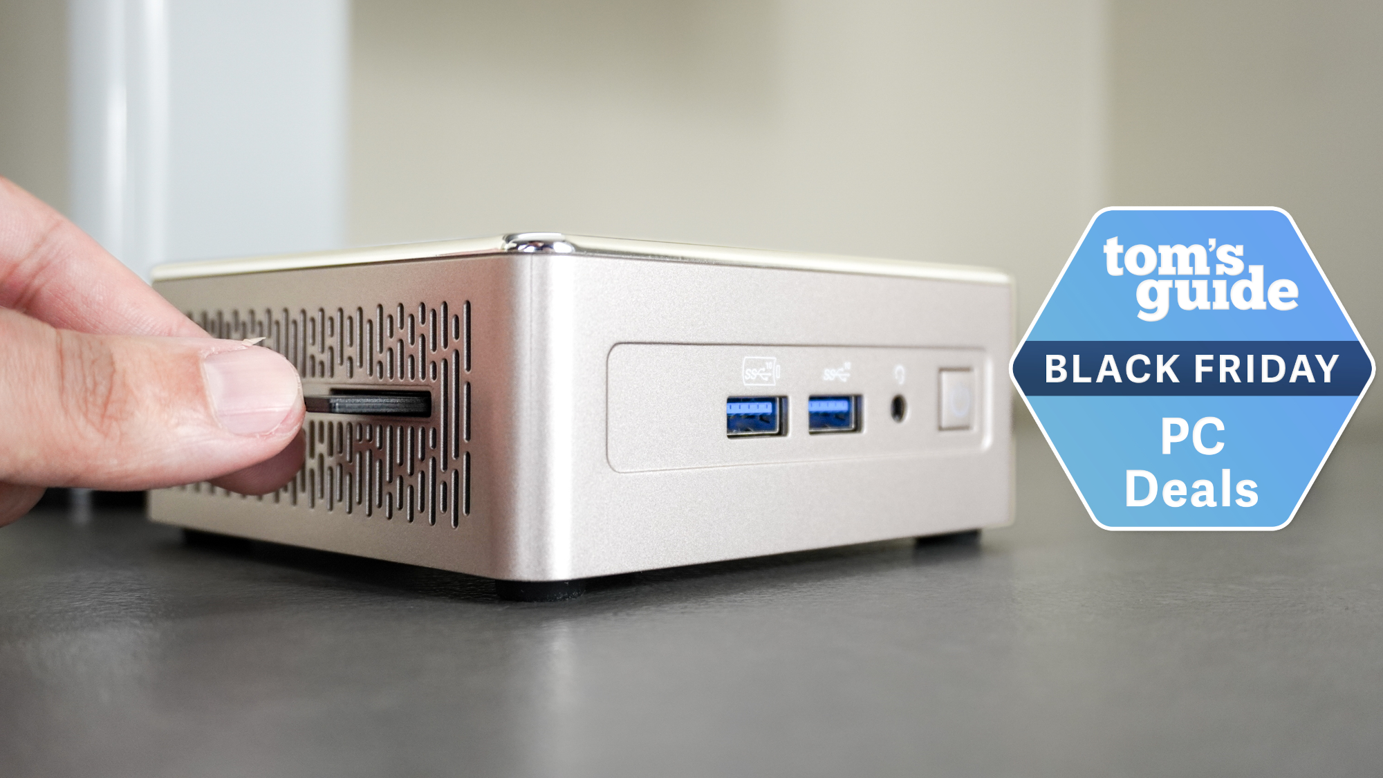 The Geekom A5 mini PC on a desk with a Tom's Guide Black Friday deals badge