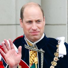 Kate Middleton and Prince William wave while wearing ceremonial robes on the Buckingham Palace balcony