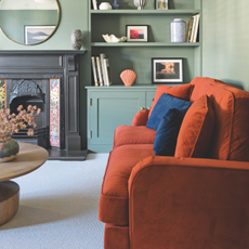 red sofa with blue cushioms in a green living room