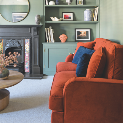 red sofa with blue cushioms in a green living room