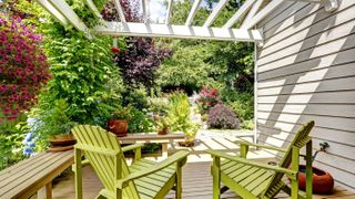 Garden with green painted Adirondack chairs and overhead white beams