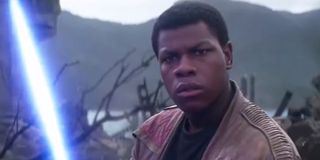 Finn (John Boyega) holds a lightsaber