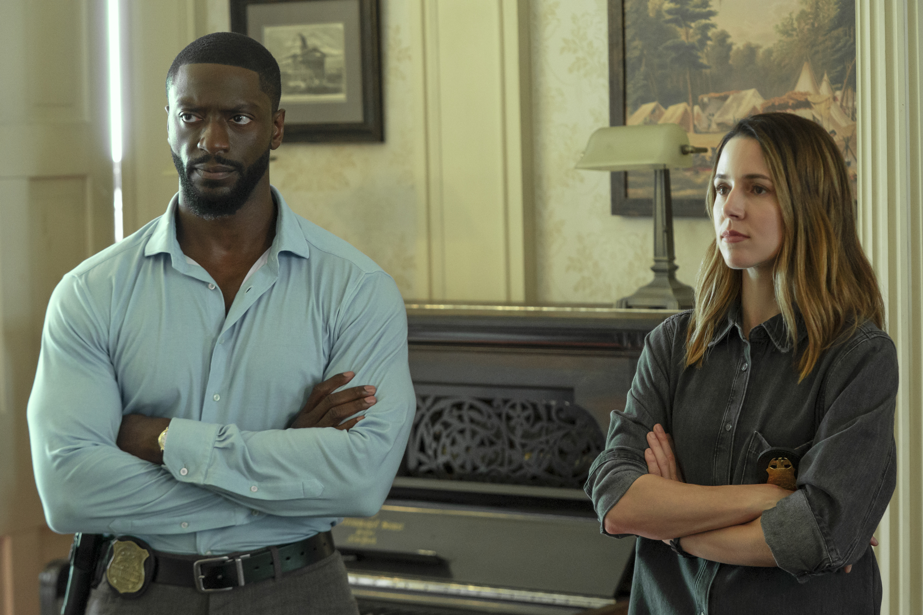 Alex Cross (Aldis Hodge) and Kayla Craig (Alona Tal) stand with their arms crossed in a fancy looking room in cross season 2