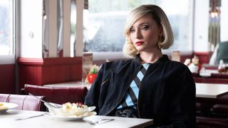 Sophie Turner as Joan in ITV's Joan, sitting in a diner with a banana split in front of her