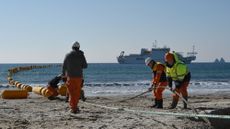 Employees install a subsea cable on the ocean shore in southern France. 
