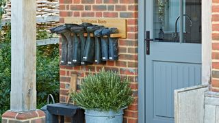 timber frame open porch with storage for hanging wellington boots outside the door