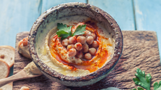 A bowl of hummus topped with chickpeas and olive oil
