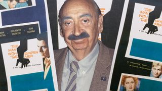 Photo of Saul Bass with Hitchcock posters