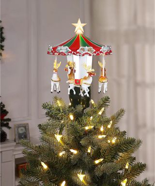 A rotating carousel Christmas tree topper with horse figurines and LED lights