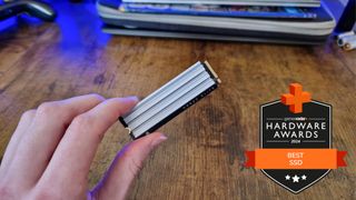 Reviewer's hand holding Corsair MP600 Elite SSD with GamesRadar+ Hardware Awards badge