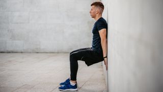 Man performing wall sit leg exercise