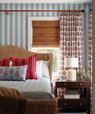 Bedroom with blue and white striped wallpaper and patterened curtains