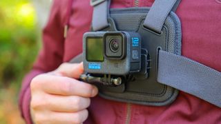 A close up of a GoPro Chesty V2 harness with GoPro Hero 12 Pro attached on a man wearing a red coat