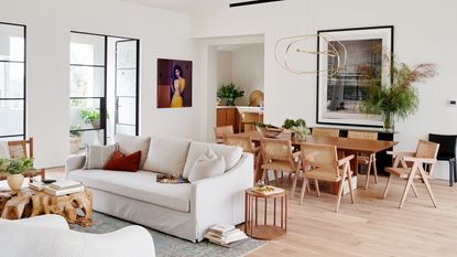 a modern neutral living room with a dining table and sofa